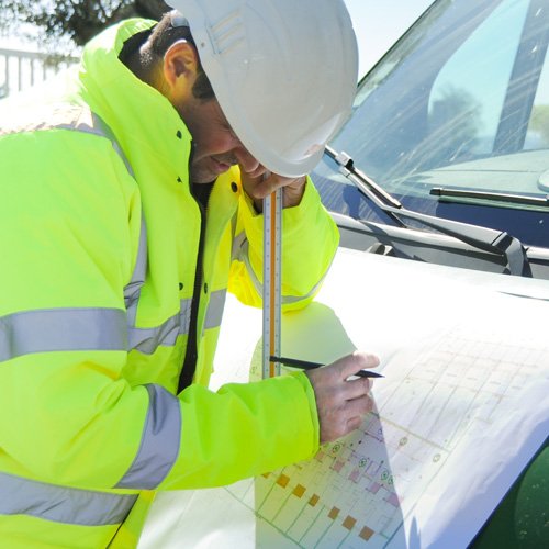 Conducteur de travaux étudiant un plan de chantier Conducteur de travaux étudiant le plan d'un chantier en aménagements paysagers